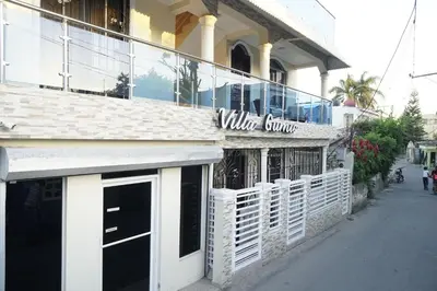 a white building with a window store on a street at Villa Gumio 2BR Apt- 7 min walk to Boca Chica Beach apts in Boca Chica