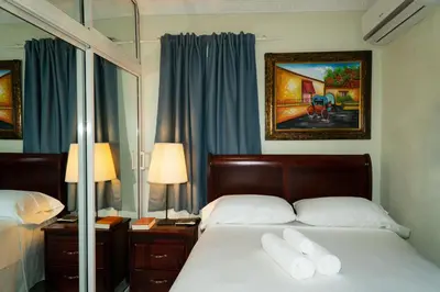 a bedroom with a bed with two white pillows at Villa Gumio 2BR Apt -7min walk Boca Chica Beach apts in Boca Chica