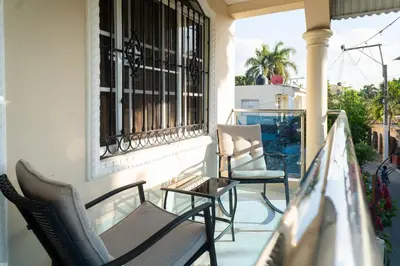 a balcony with chairs and a table and a window at Villa Gumio 2BR Apt -7min walk Boca Chica Beach apts in Boca Chica