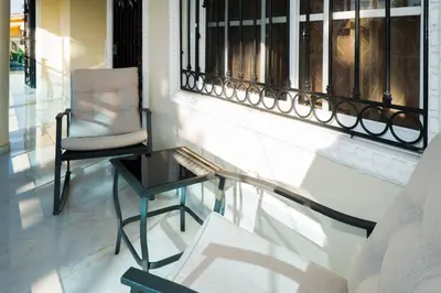 a chair and a glass table on a balcony at Villa Gumio 2BR Apt -7min walk Boca Chica Beach apts in Boca Chica
