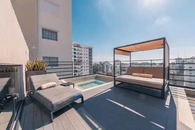 a balcony with a bed and a pool on a building at Breakfast Included at Regatta Living 605 in Los Prados