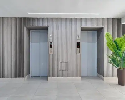 a row of elevators in a building with a plant at Central Suites Tower in Santo Domingo