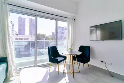 a room with a table and chairs and a large window at Central Suites Tower in Santo Domingo
