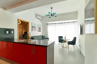 a kitchen with red cabinets and a living room at Central Suites Tower in Santo Domingo