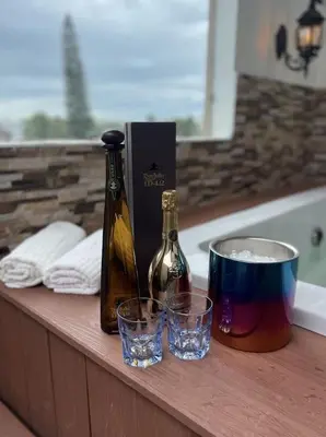 a bottle of wine and two glasses on a bathroom counter at Luxury 5 Beds Penthouse - Private Jacuzzi & Karaoke Bar & Free Parking in Santiago de los Caballeros