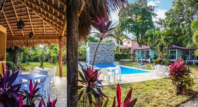 a patio with a table and chairs and a swimming pool at Bungalow Natura Village in Sosúa