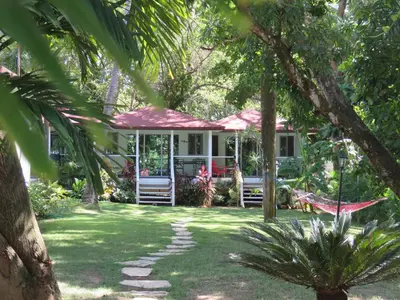 a house with a hammock in the middle of a yard at Bungalow Natura Village in Sosúa