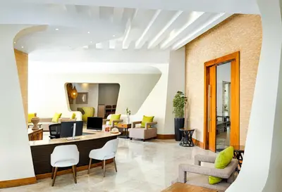 an office lobby with yellow chairs and a desk at Sunscape Dominicus La Romana - All Inclusive in Bayahibe
