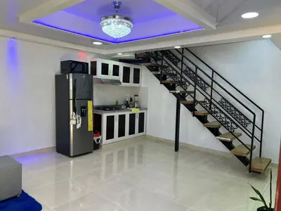a room with a staircase with a refrigerator in it at Alojamiento paulino in Santiago de los Caballeros