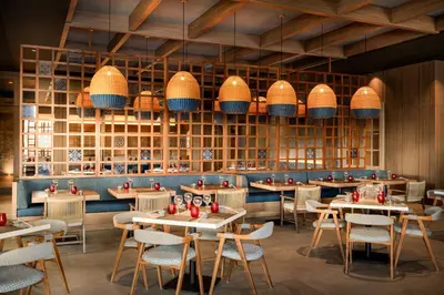 a restaurant with tables and chairs and chandeliers at Secrets Tides Punta Cana - All Inclusive in Punta Cana