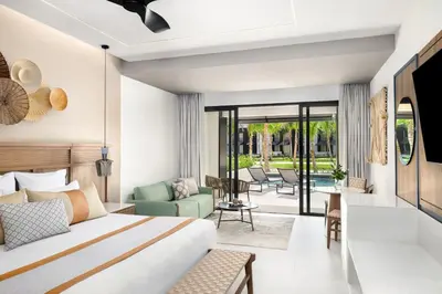 a bedroom with a bed and a living room at Secrets Tides Punta Cana - All Inclusive in Punta Cana