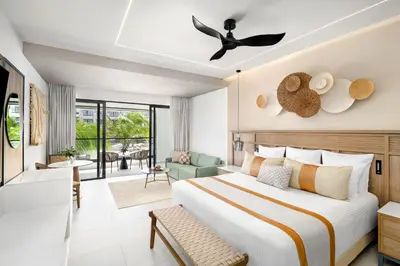 a bedroom with a bed and a living room at Secrets Tides Punta Cana - All Inclusive in Punta Cana
