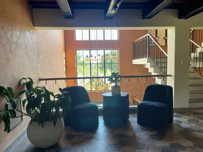 a lobby with two blue chairs and a window at Hotel Pinar Dorado By Hotel Gran Jimenoa in Jarabacoa