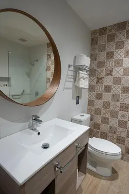 a bathroom with a sink and a toilet and a mirror at Hotel Pinar Dorado By Hotel Gran Jimenoa in Jarabacoa