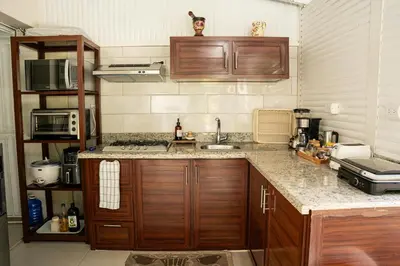a kitchen with wooden cabinets and a counter top at Habitación privada en Puerto Plata Bayardo in San Felipe de Puerto Plata