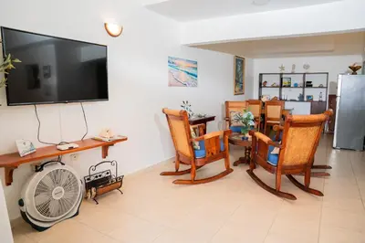 a living room with a fan and chairs and a tv at Apartamento Los Anturios en Puerto Plata Bayardo in San Felipe de Puerto Plata