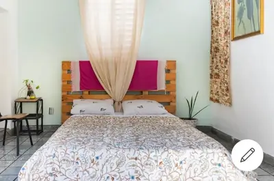 a bedroom with a large bed with a wooden headboard at Room in the Colonial Zone in Santo Domingo