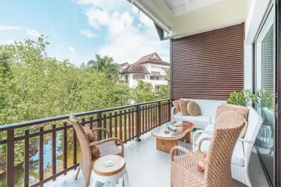 a balcony with wicker furniture and a view of the water at Nearby beach and beach club at Portillo NF in Las Terrenas