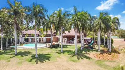 an aerial view of a house with palm trees at Luxurious 8-BR Villa with Ocean View, Jacuzzi, Home Cinema and Resort Access in Casa de Campo in La Romana