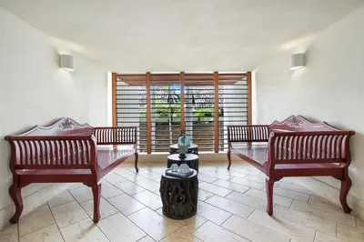 a living room with two benches and a window at Luxurious 8-BR Villa with Ocean View, Jacuzzi, Home Cinema and Resort Access in Casa de Campo in La Romana