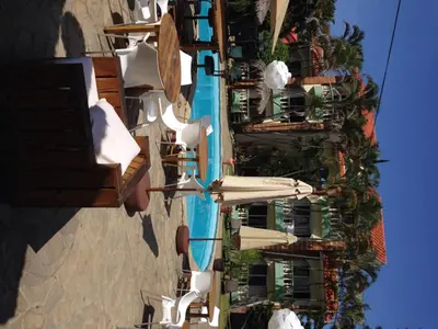 a building with a pool and chairs and a building at Hotel Voramar in Sosúa