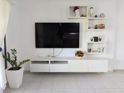 a white entertainment center with a flat screen tv on a wall at Apartamento a 5 min de la playa in San Felipe de Puerto Plata