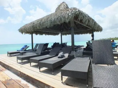a group of chairs and an umbrella on a beach at Appartamenti in Cadaques Caribe in Bayahibe