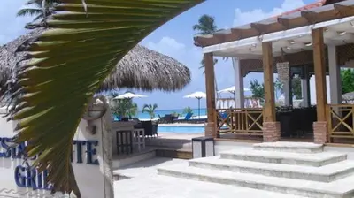 a resort with a swimming pool and a resort with a palm leaf at Appartamenti in Cadaques Caribe in Bayahibe
