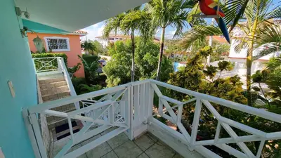a balcony with a white fence and palm trees at Villa Preciosa in Bayahibe