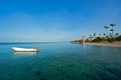 a boat in the water next to a beach at Casa Vacanze Dume in Bayahibe