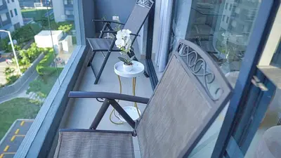 a balcony with a chair and a table with flowers at Premium space in Santiago- 5 Min Away from airport in Santiago de los Caballeros