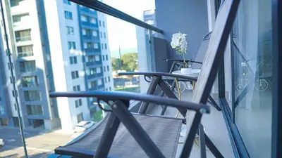 a chair on a balcony with a view of a city at Premium space in Santiago- 5 Min Away from airport in Santiago de los Caballeros