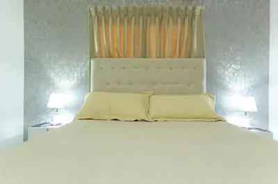 a bedroom with a white bed with two lamps at MB Apartment - A in San Felipe de Puerto Plata