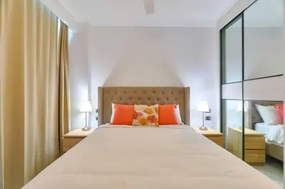 a bedroom with a large bed with orange pillows at Luxury Apartment at Cana Rock Star Punta Cana DR in Punta Cana