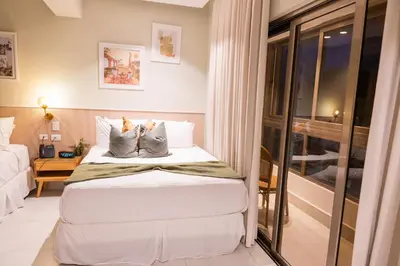 a hotel room with a bed and a window at Hotel Stay Here Suites in Santo Domingo