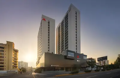 two tall buildings in a city with a street at Santo Domingo Marriott Hotel Piantini in Santo Domingo