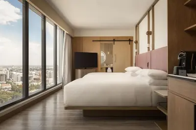 a bedroom with a white bed and large windows at Santo Domingo Marriott Hotel Piantini in Santo Domingo