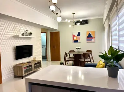 a living room with a television and a dining room at Luxury 1 BDR , Rooftop POOL, Gym, in Downtown D2 in Santo Domingo