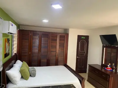 a bedroom with a bed and a dresser with a television at Apartament para pareja muy acogedor y privado in Cafemba