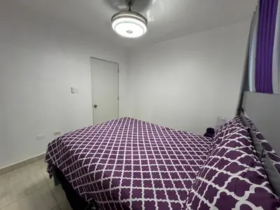 a bedroom with a purple comforter on a bed at Joel Arturo Residences in Licey al Medio