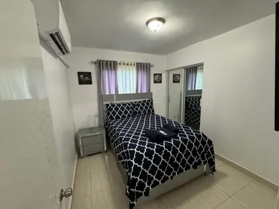 a bedroom with a bed with a black and white comforter at Joel Arturo Residences in Licey al Medio