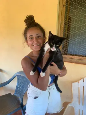 a woman holding a black and white cat at La Hacienda Hostel-Rancho in Las Galeras