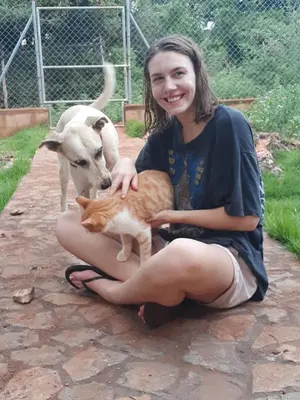 a woman is holding a cat and a dog at La Hacienda Hostel-Rancho in Las Galeras
