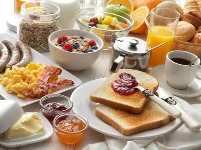 a table with a breakfast of toast and breakfast foods at Villa Palmas Doradas in Cabarete