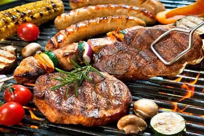 a bunch of meats and vegetables on a grill at Villa Palmas Doradas in Cabarete