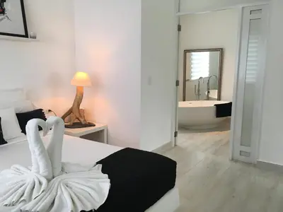 a bedroom with a bed and a bathroom with a tub at Casa Veintiuno in Sosúa