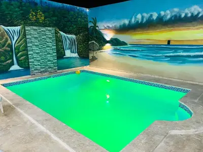a swimming pool in a house with a painting on the wall at R.G sol 2 in Pantoja