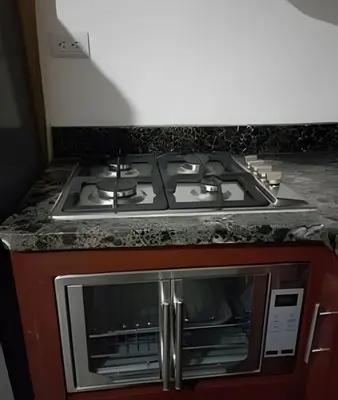 a stove top oven sitting next to a microwave at Apart hotel Costa Verde Exclusivo y Seguro #5 con cama Queen in Las Galeras