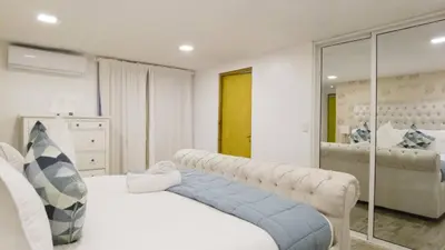 a bedroom with a white bed and a mirror at 8BR Penthouse Jacuzzi, Pool Table Terrace in Los Prados