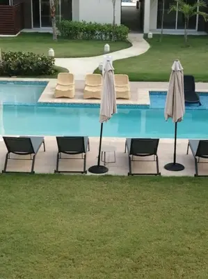 a group of chairs and umbrellas next to a pool at Casa Larimar 214 - Vibe Residence in La Laguna